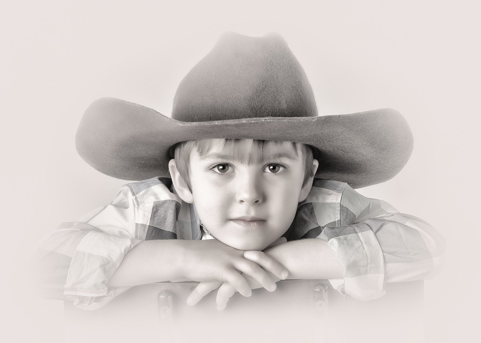 Portrait of a young boy in a cowboy hat taken at a San Antonio professional photographer's studio
