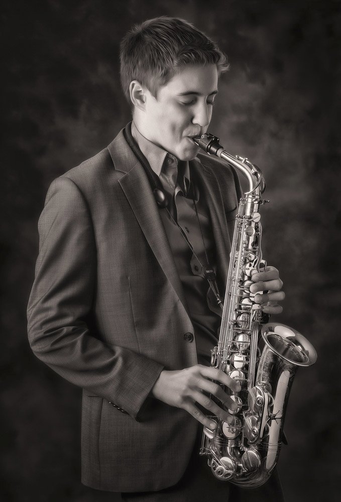 High school senior portrait featuring a band instrument in a San Antonio portrait studio