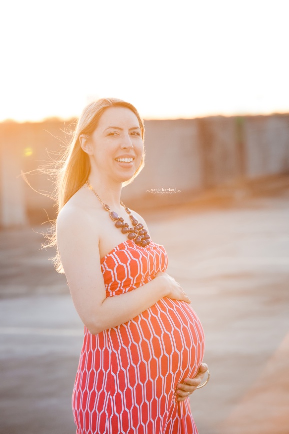 maternity photo of woman in red dress on rooftop in Charlotte, NC
