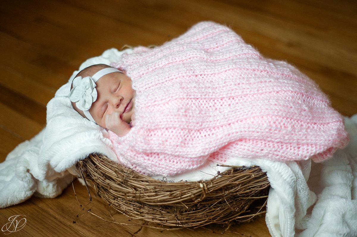 photo of newborn in basket smiling