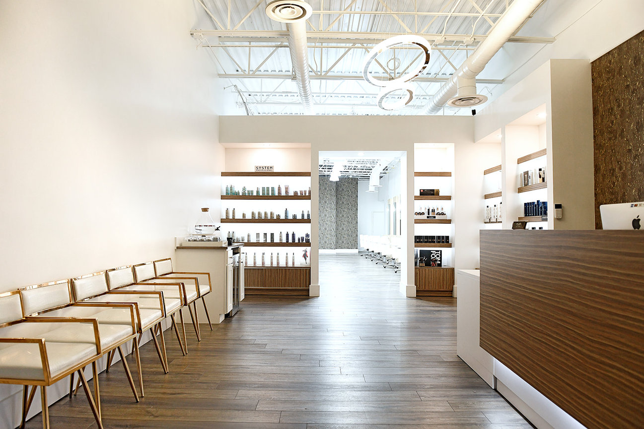 Modern salon interior featuring stylish seating, product displays, and a sleek reception area.
