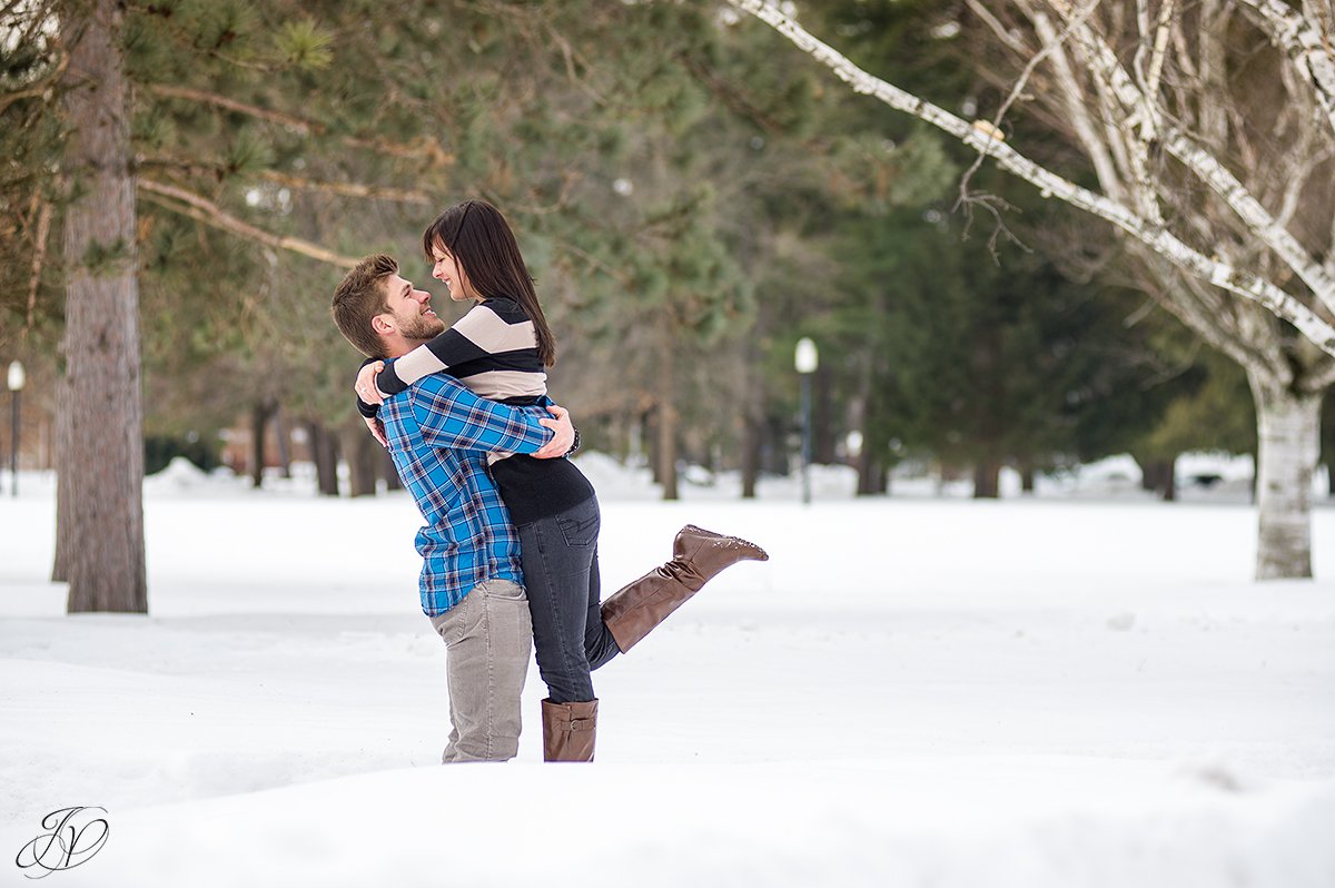 photo of a guy picking up his fiance in the snow