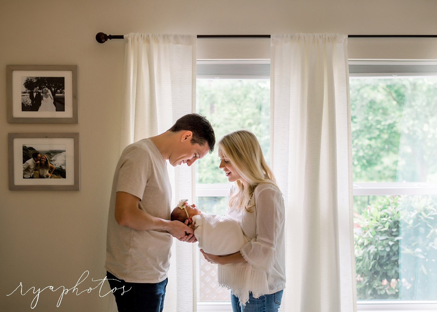 mom and dad looking at newborn baby girl, backlit newborn portrait, Ryaphotos