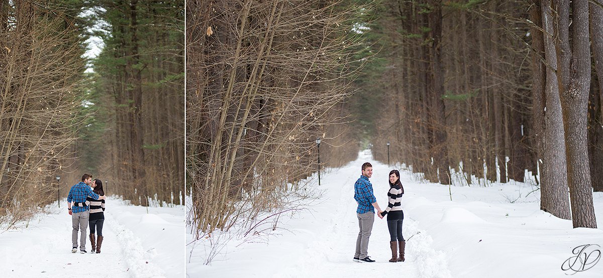 engaged couple walking in trees in winter