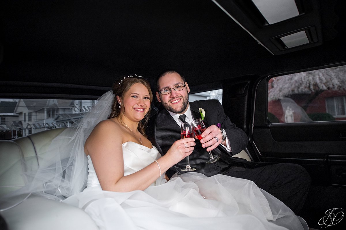 bride and groom toasting in limousine