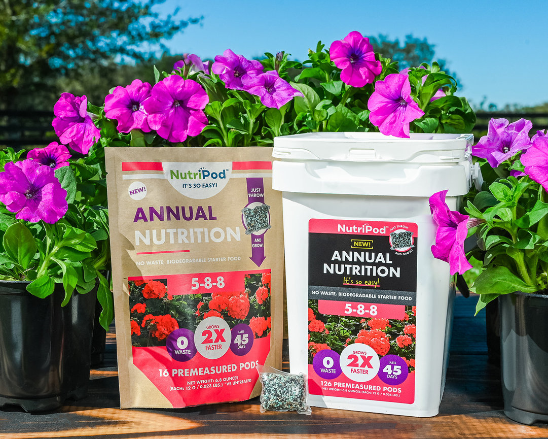NutriPod annual nutrition starter food in bags and container, surrounded by colorful petunia flowers.