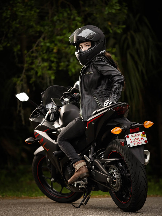 Senior girl posing with her gorgeous sports bike in a sunny day