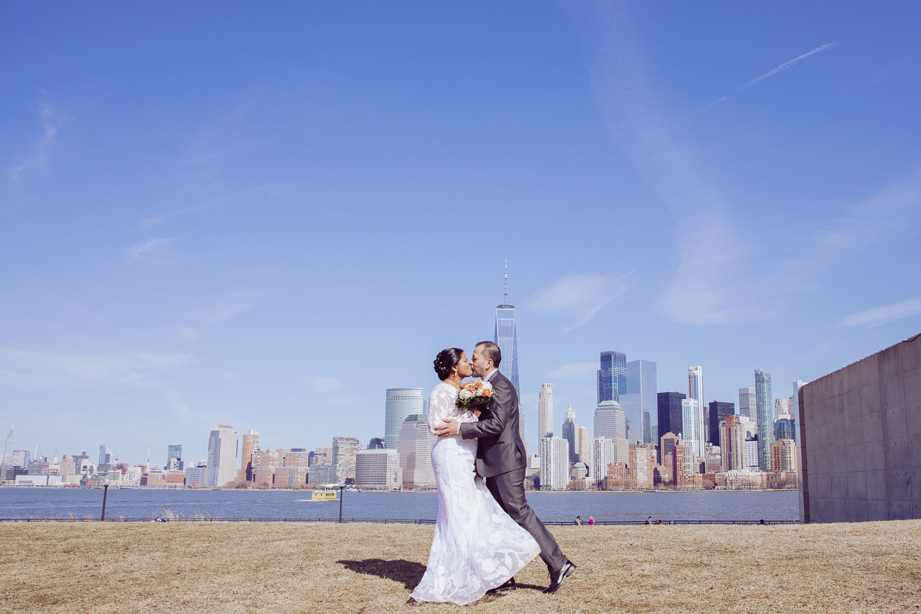 bride and groom kissing during wedding portraits at liberty state park