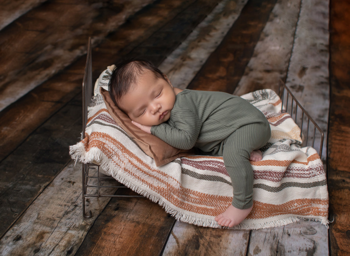 Newborn baby sleeping in tiny bed, photo session in Weslaco, TX