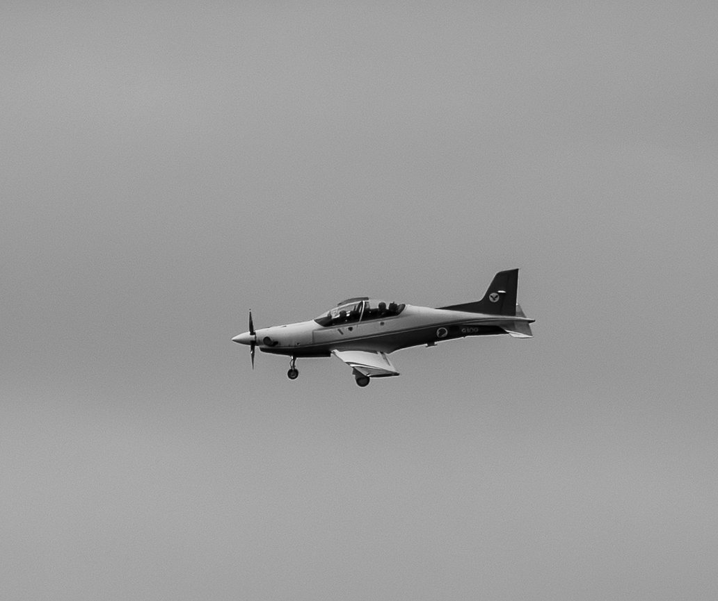 Propeller airplane flying through overcast sky