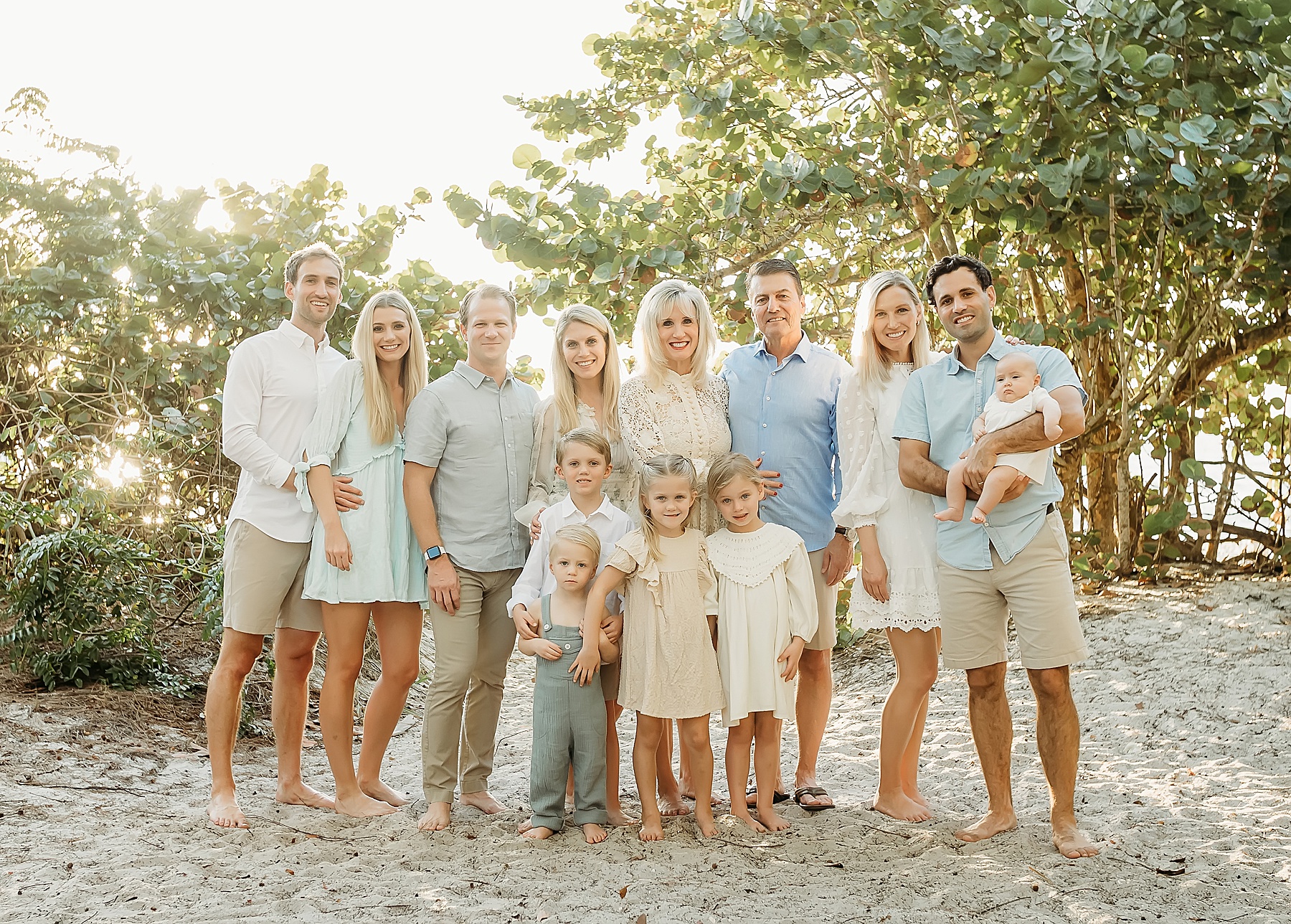 extended family of people standing in pastel clothing on the beach in Naples, Florida at Wiggins Pass State Park