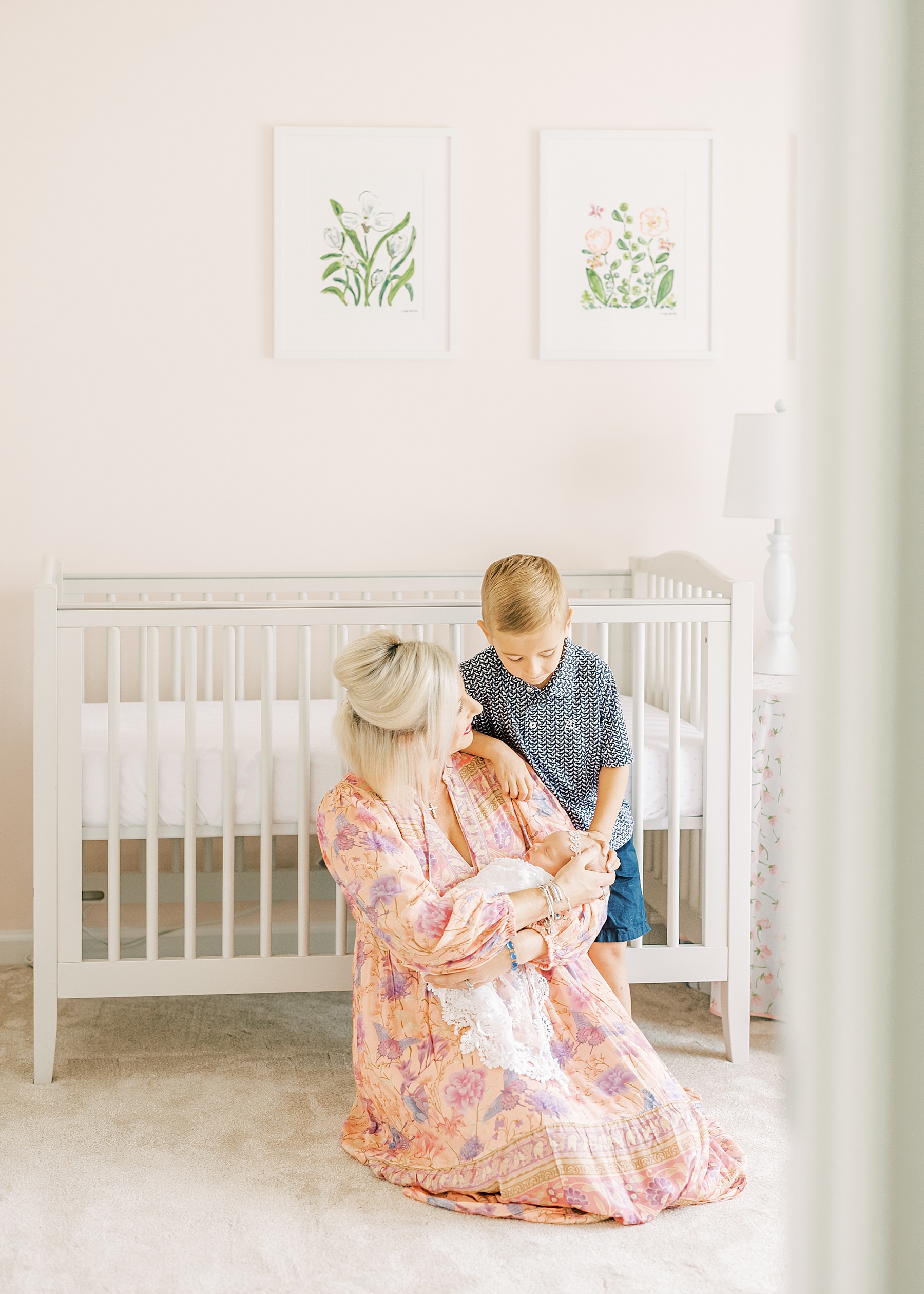 woman and little boy with newborn baby girl, pink newborn baby room, woman in maxi dress, pink dress, sitting woman, little boy in blue