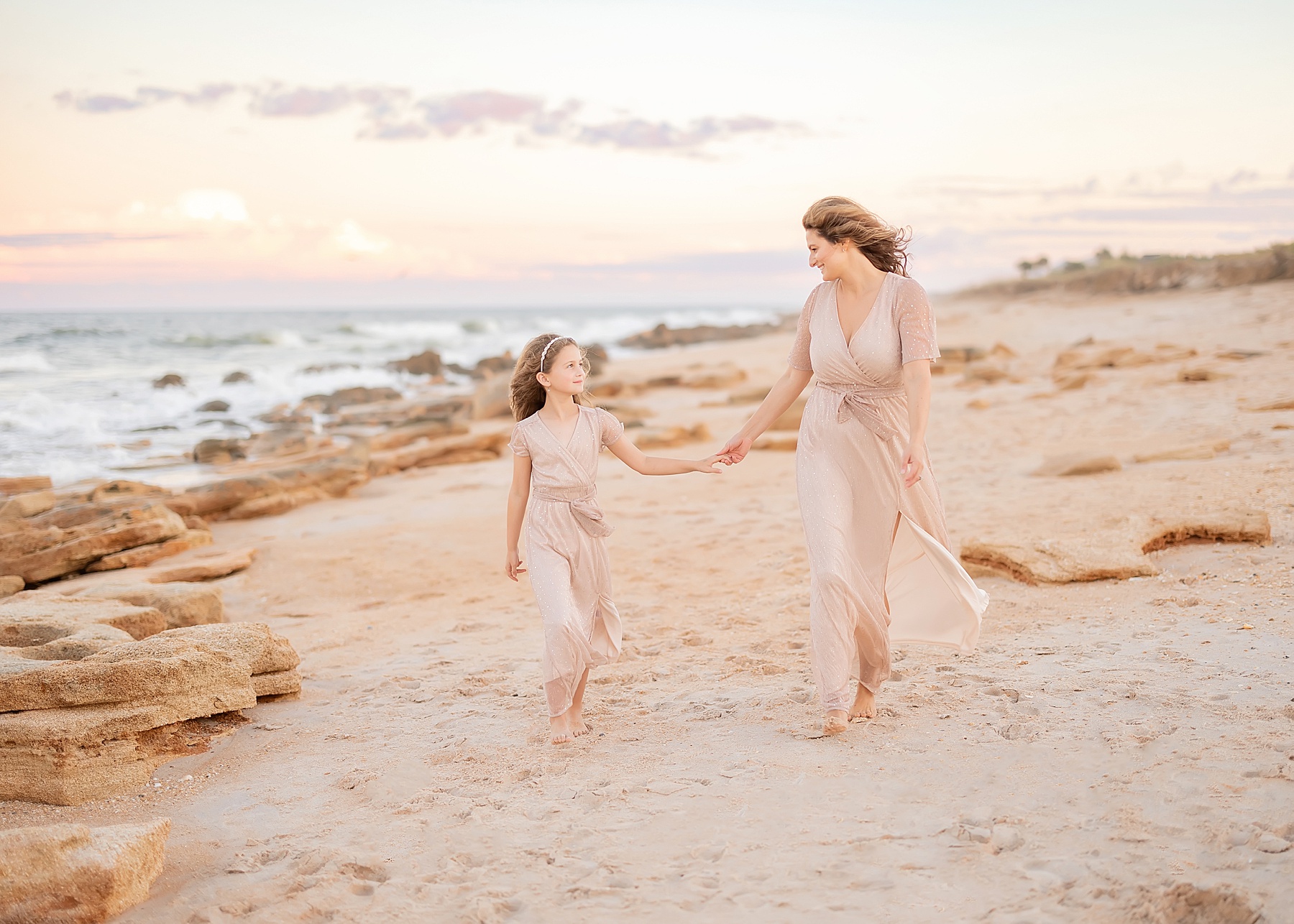 a soft light pastel mother and daughter portrait at sunset on the beach in saint augustine florida