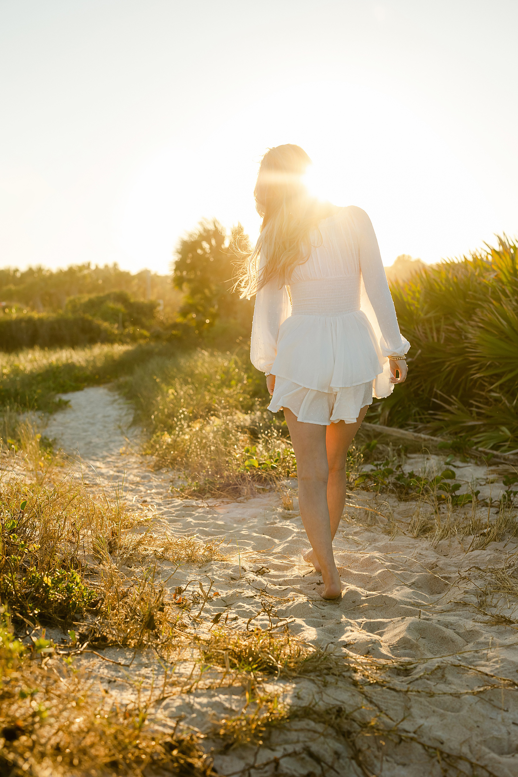 blonde hair girl on walking into the sunlight on the coast in saint augustine florida