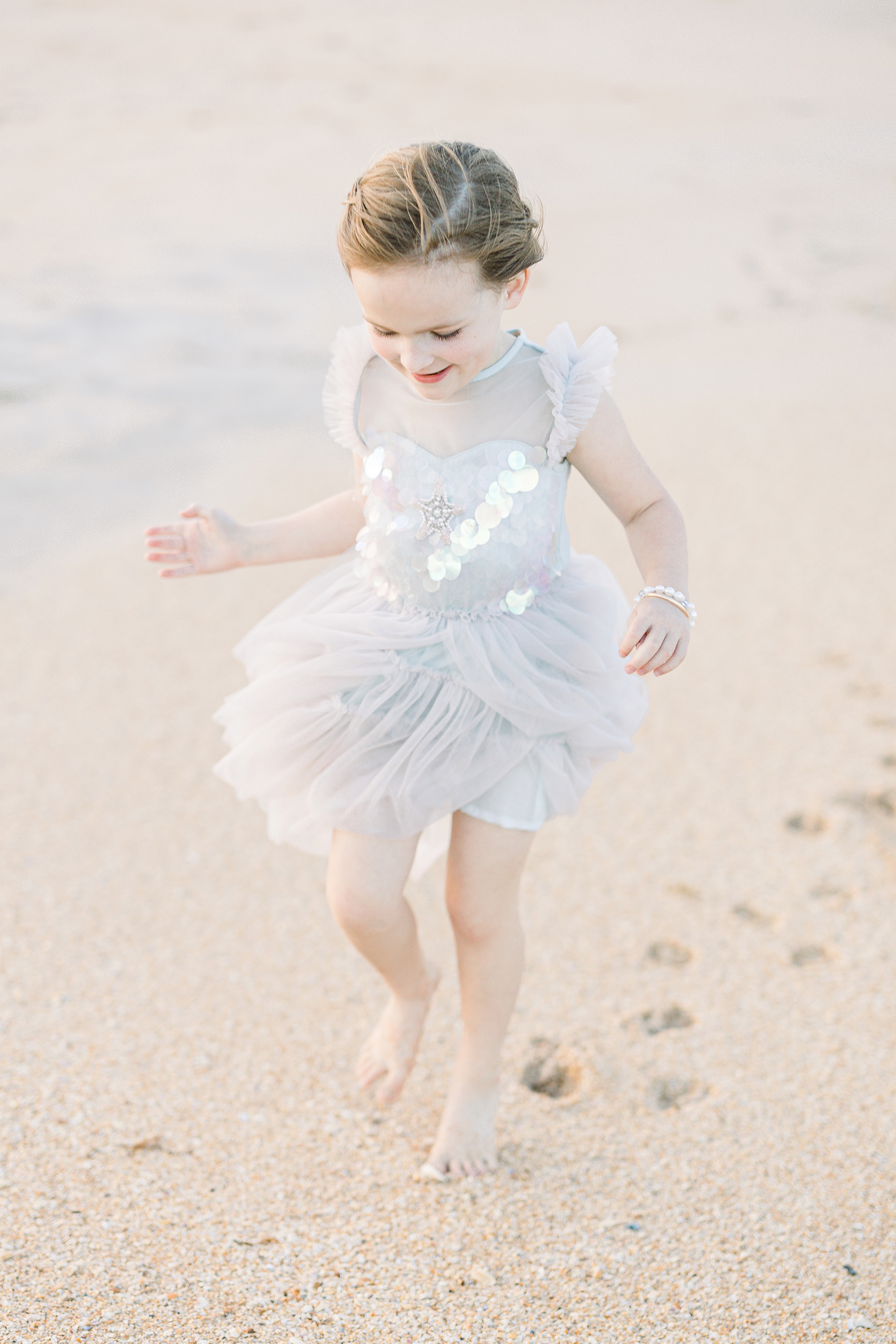 little girl in pastel tutu dress dancing near the shoreline in Saint Augustine Florida