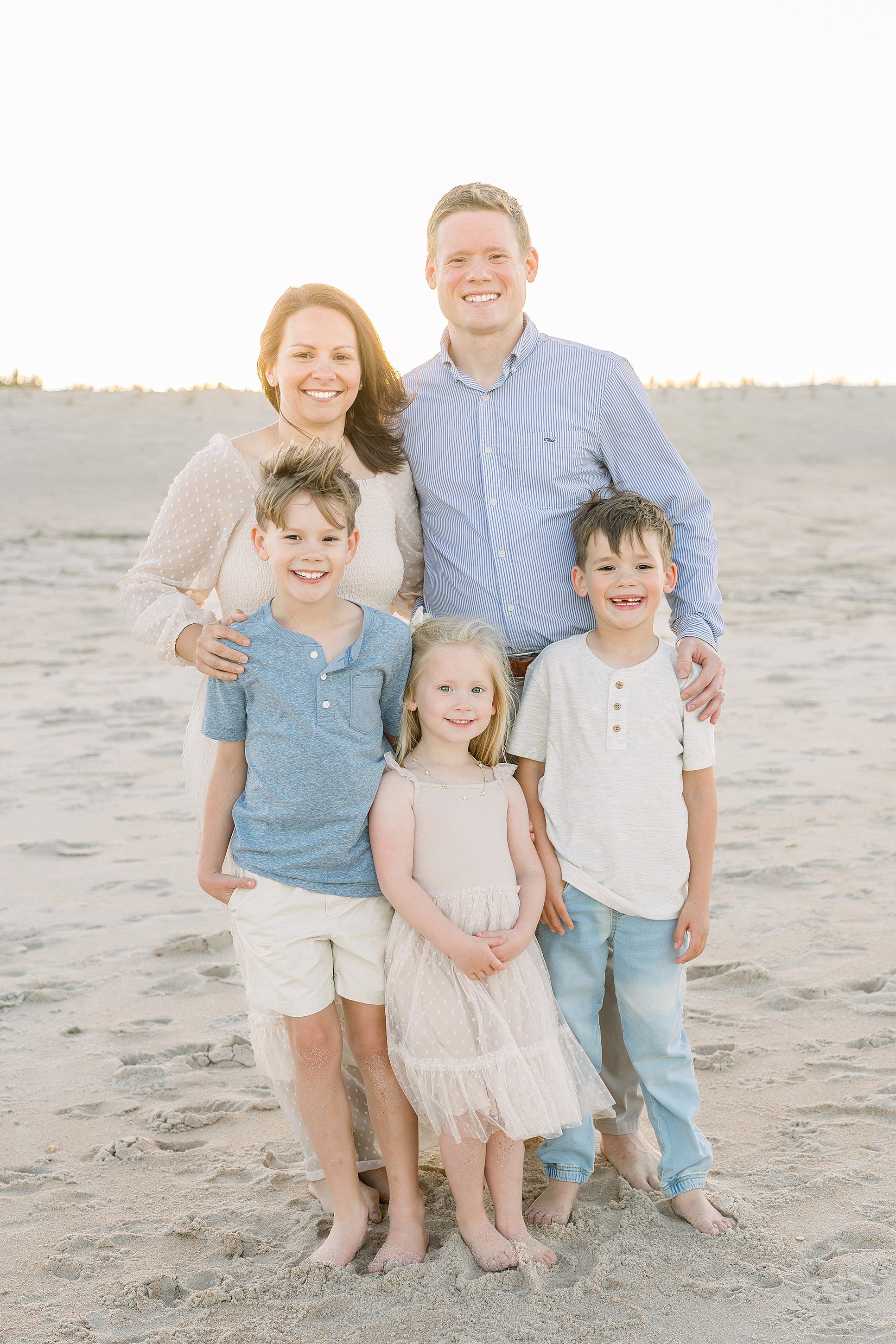 A family of five stands together on the beach at sunset in St. Augustine Beach.