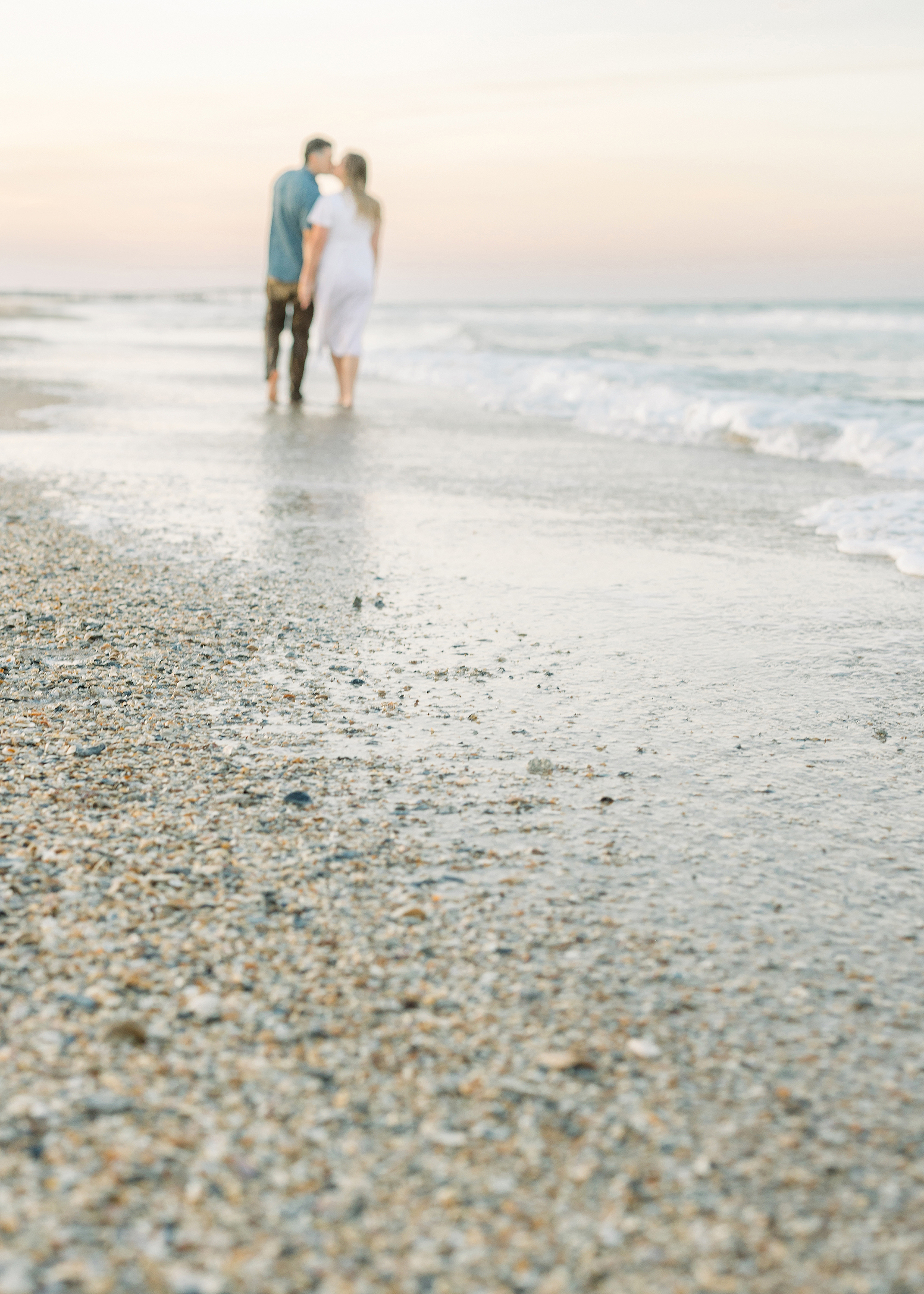 A pastel sunset portrait of a couple on St. Augustine Beach.