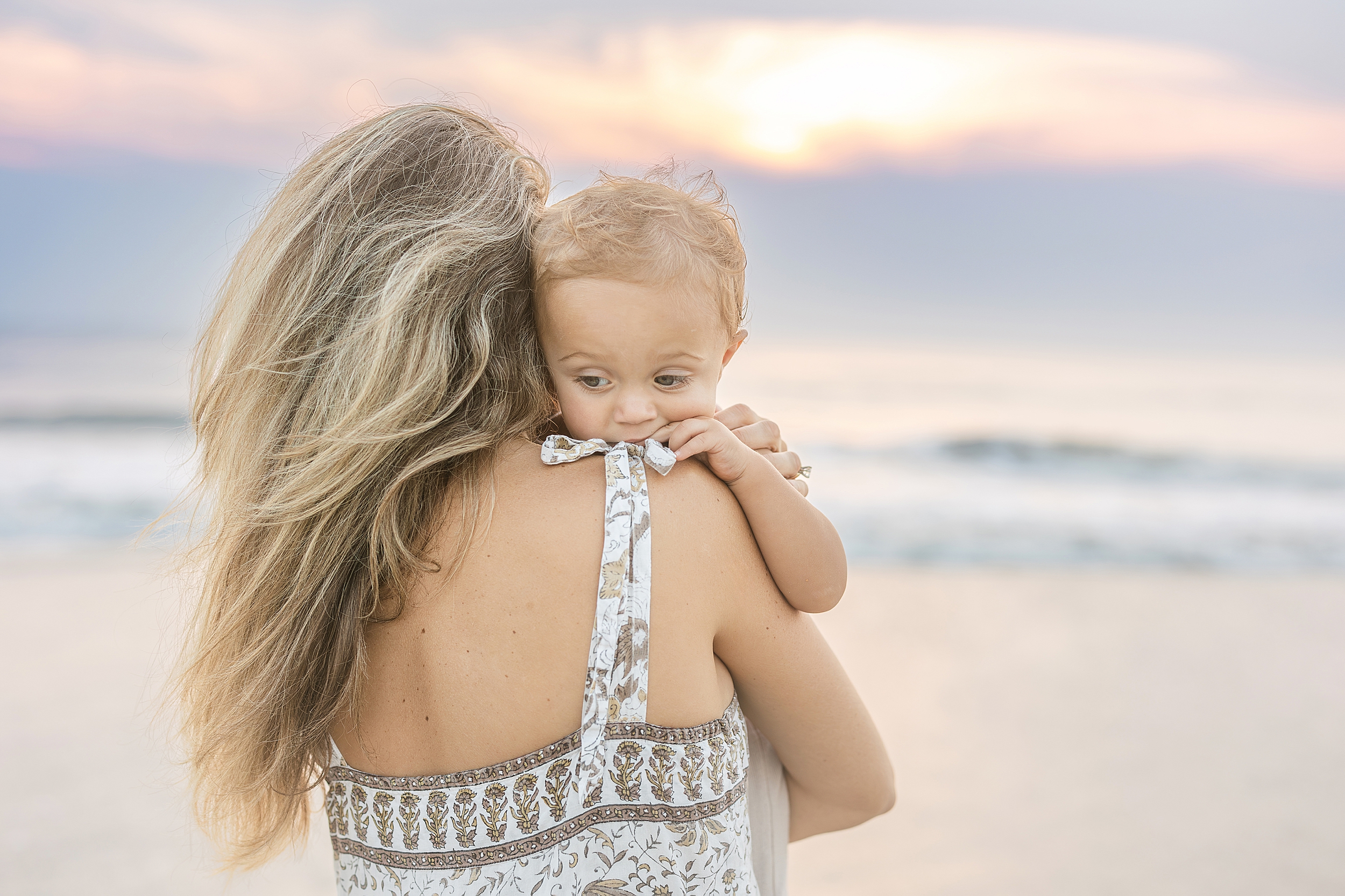 A pastel sunrise portrait of a mother and her son on St. Augustine Beach.