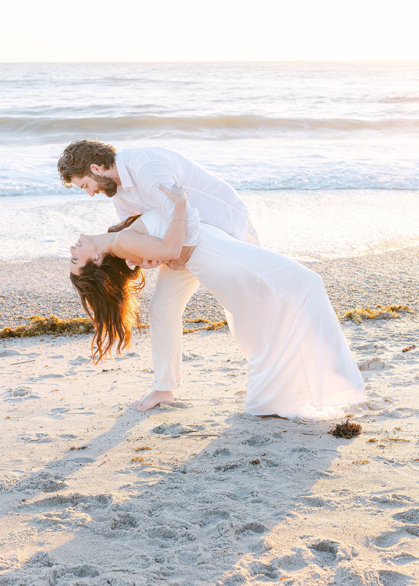 A man dips a woman at sunrise on the beach in Amelia Island, Florida.