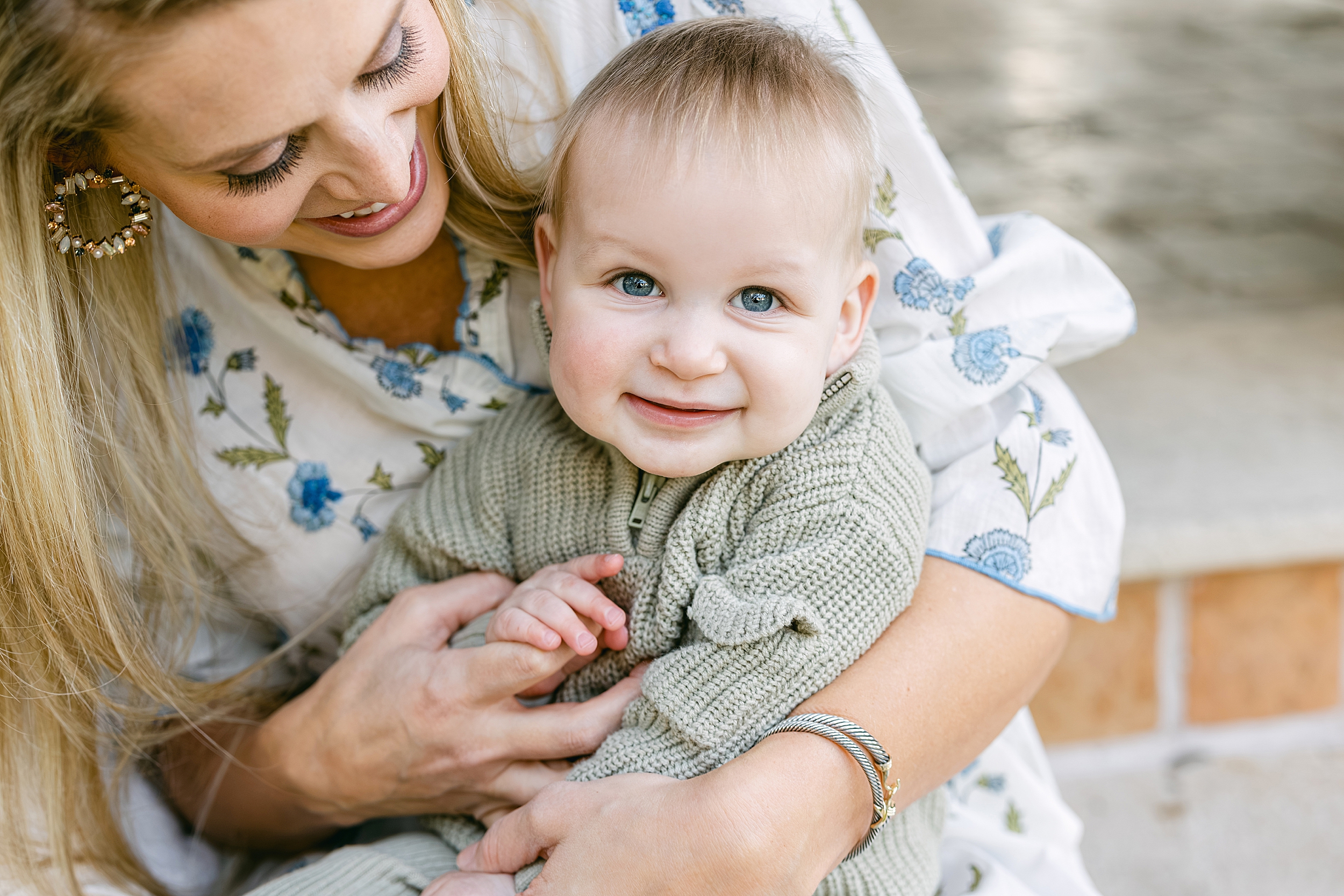 A mother holds her blue-eyed baby boy on the steps of the Cloister at Sea Island Resorts.