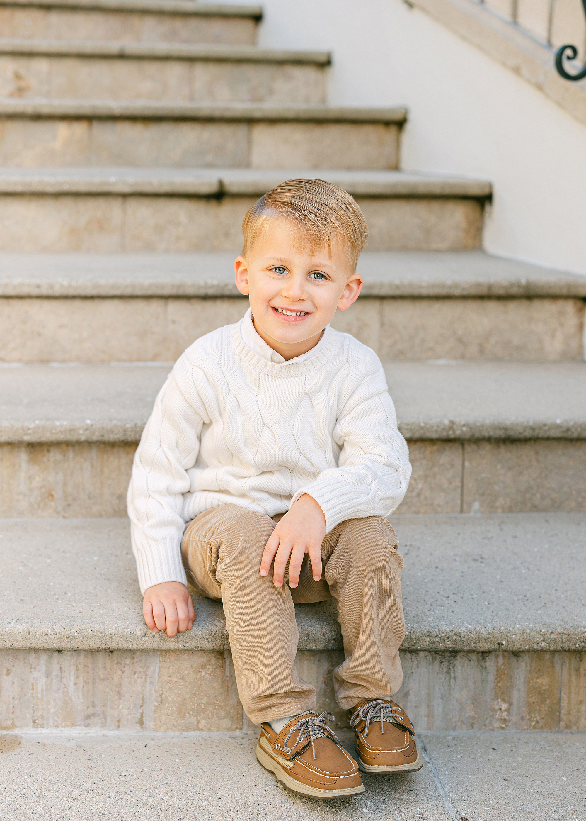 A portrait of a little boy on the steps of the Cloister at Sea Island Resorts.