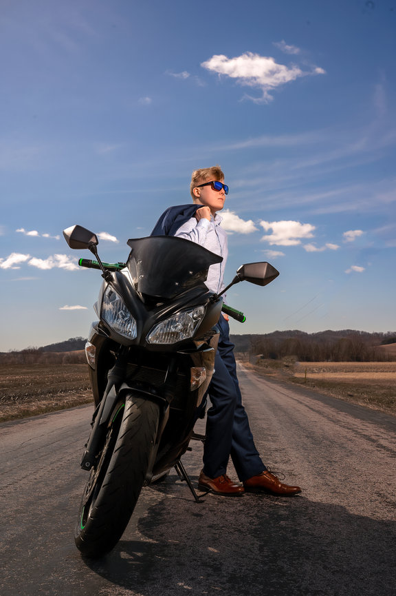 Senior Guy in blue suit resting against his motorcycle