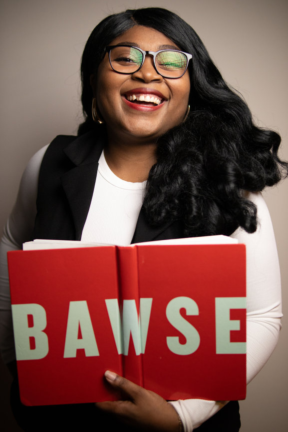 Woman holding a book titled BAWSE