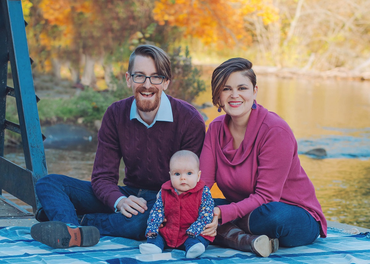 family in front of the river in the fall