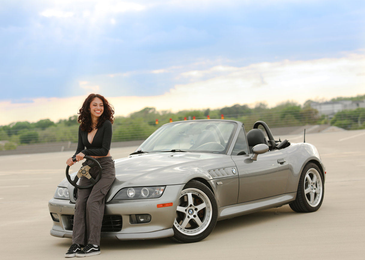 Beautiful you woman posing with her BMW at golden hour near UTA.