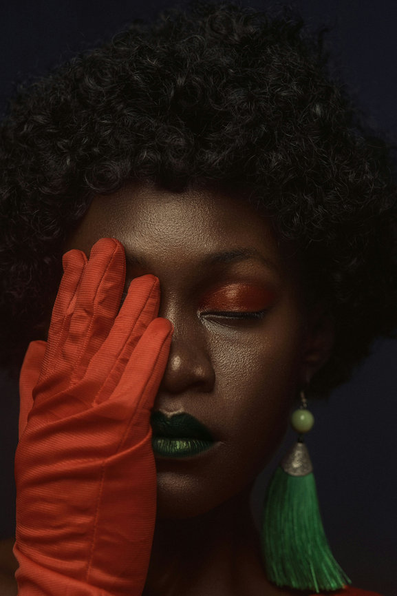 Woman covering one eye with red glove