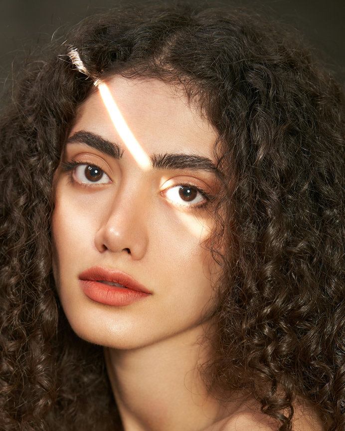 Woman with curly hair and light on face