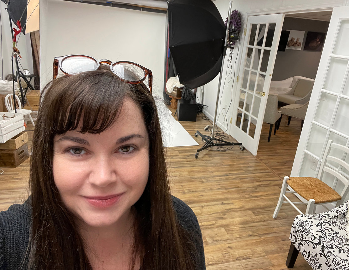 Paula Swift in her Sudbury MA photo studio with lights and a white backdrop.