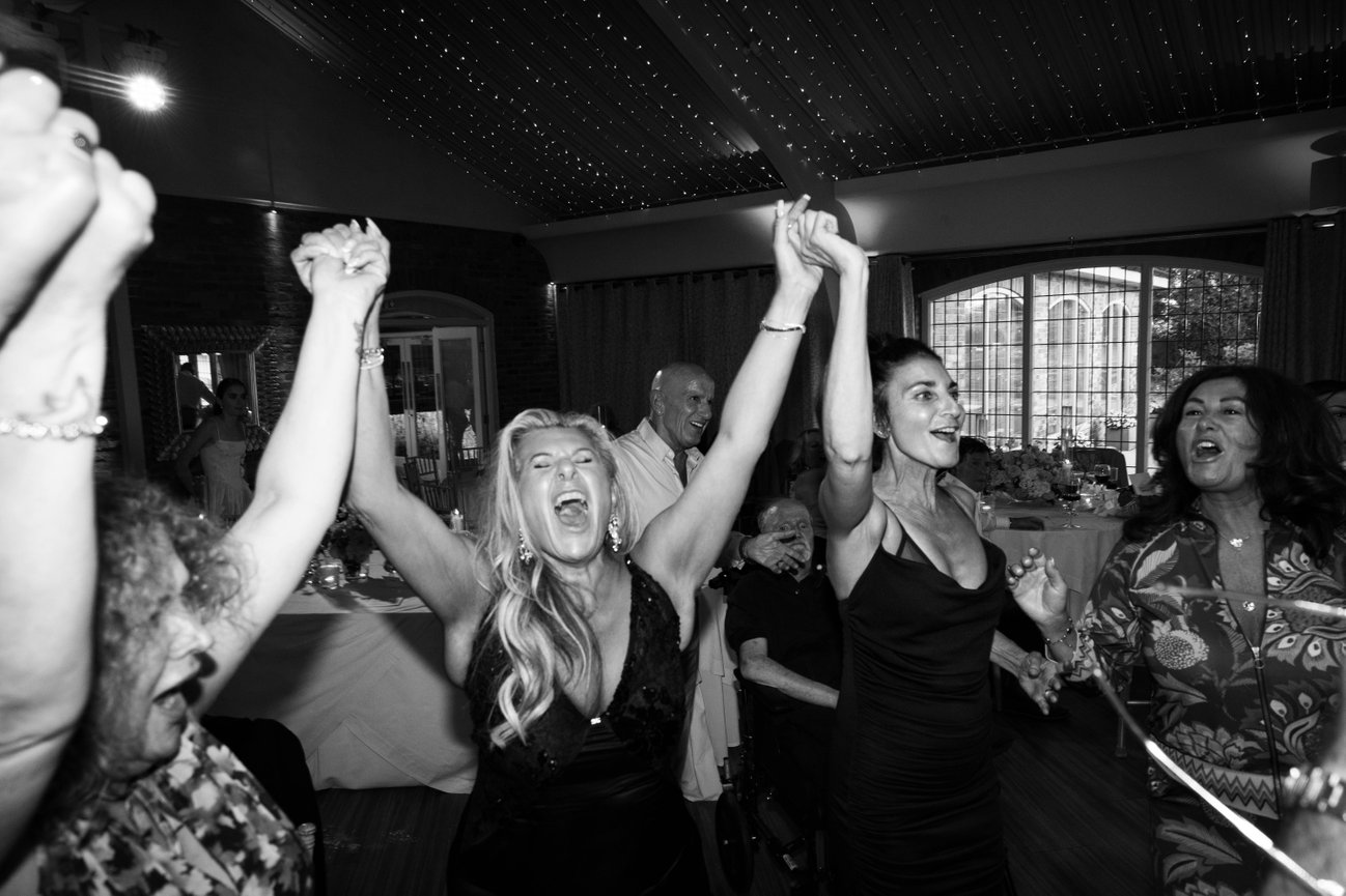 Candid black and white party photography at Colshall Hall; capturing the raw energy and fun of a wedding reception in monochrome.