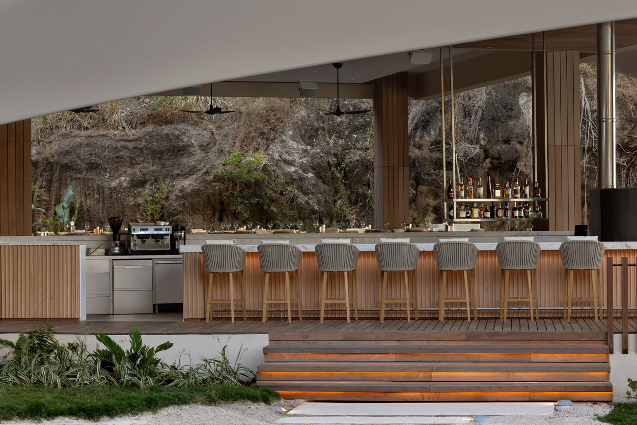 Silversands Beach House Bar and Restaurant designed with a lot of wood throughout and a rock formation backdrop from the mountain.