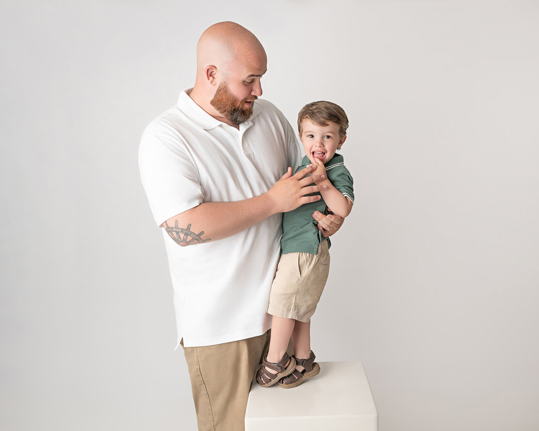 Sweet moment between father and son in clean white studio