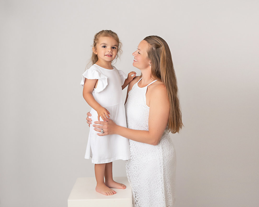 Mother and daughter smiling side by side in Holmdel family photo