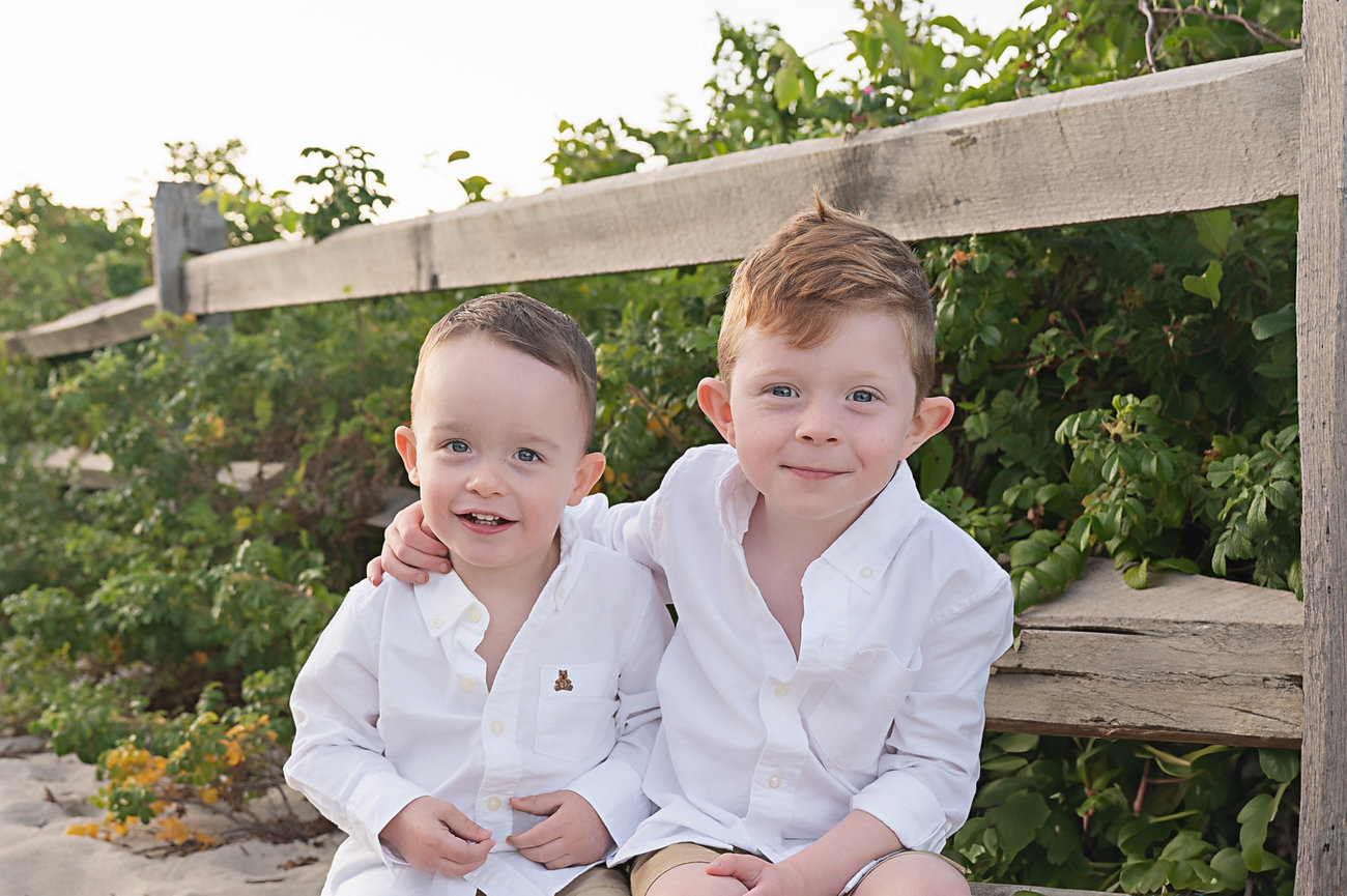 Brothers sitting close in the dunes during sunset