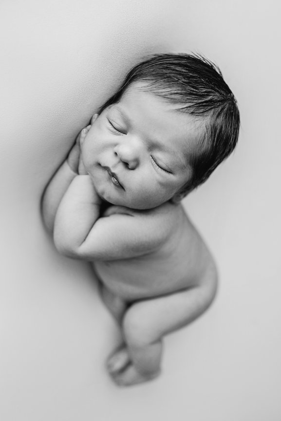 A sleeping newborn baby in black and white.