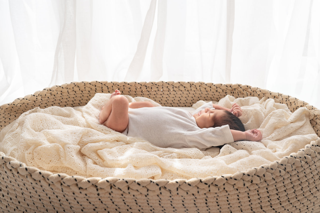 Baby stretching arms in white studio setting