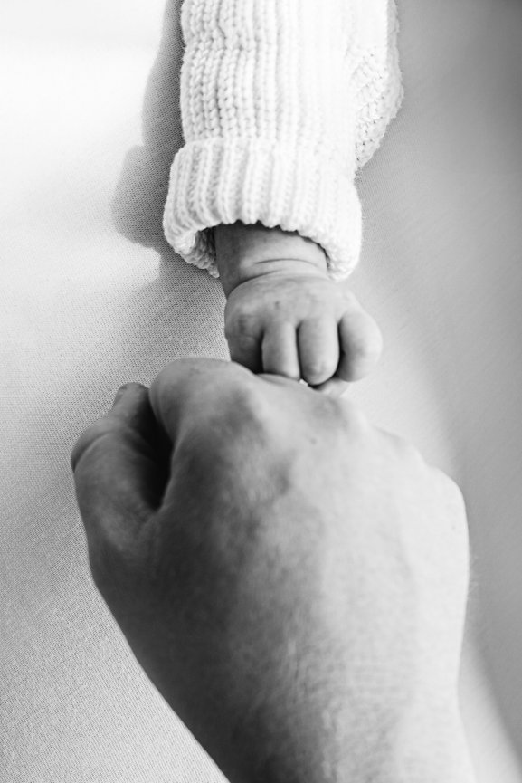 Fist bump between dad and newborn baby