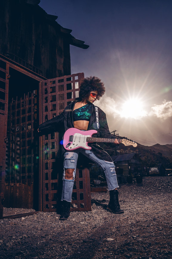 High school senior girl holding a pink guitar outdoors for music-themed senior photos in Green Bay, Wisconsin.