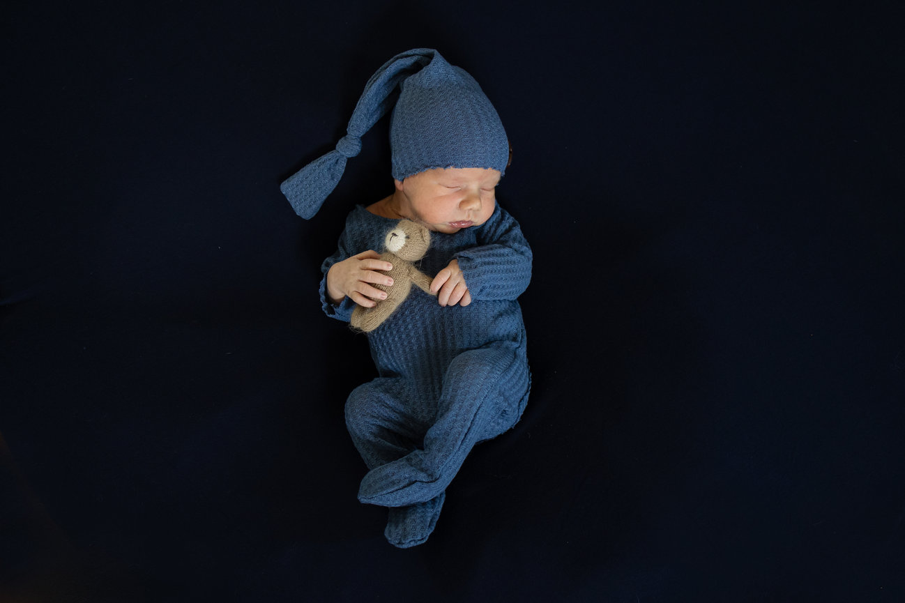 Newborn boy holding teddy bear