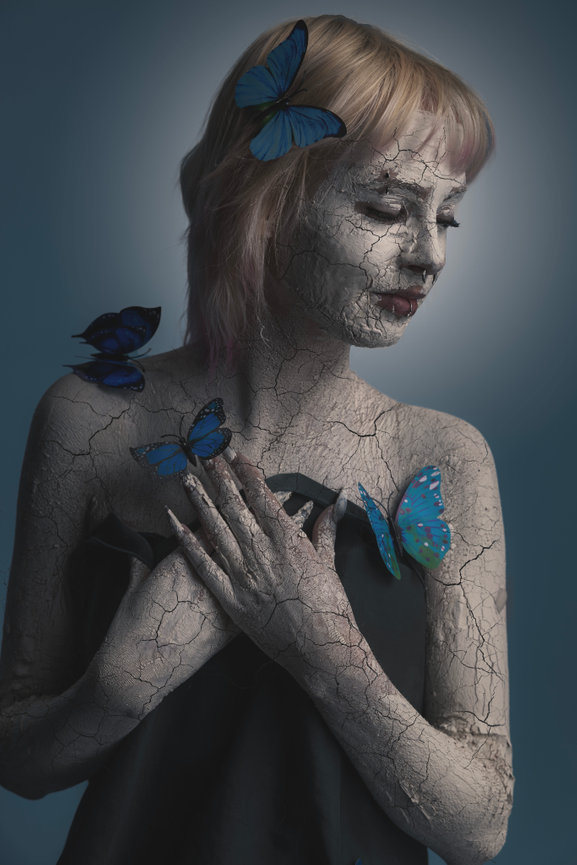 Creative Fort Worth portrait of woman with painted skin and blue butterflies, fine art photography style.