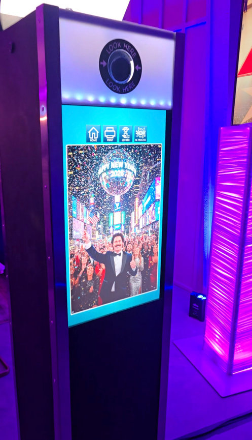 AI photo booth with interactive touchscreen displaying a stylized group portrait at an event in Cincinnati.