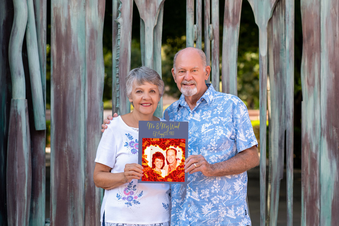 Family portrait with grandparents holding wedding picture anniversary outdoors