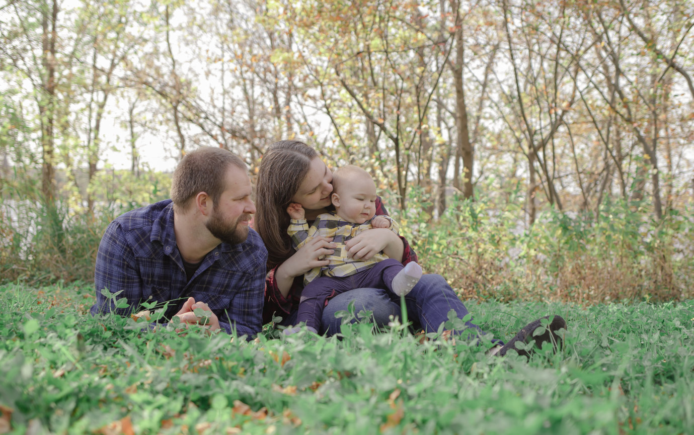 Family lying on grass in park during autumn