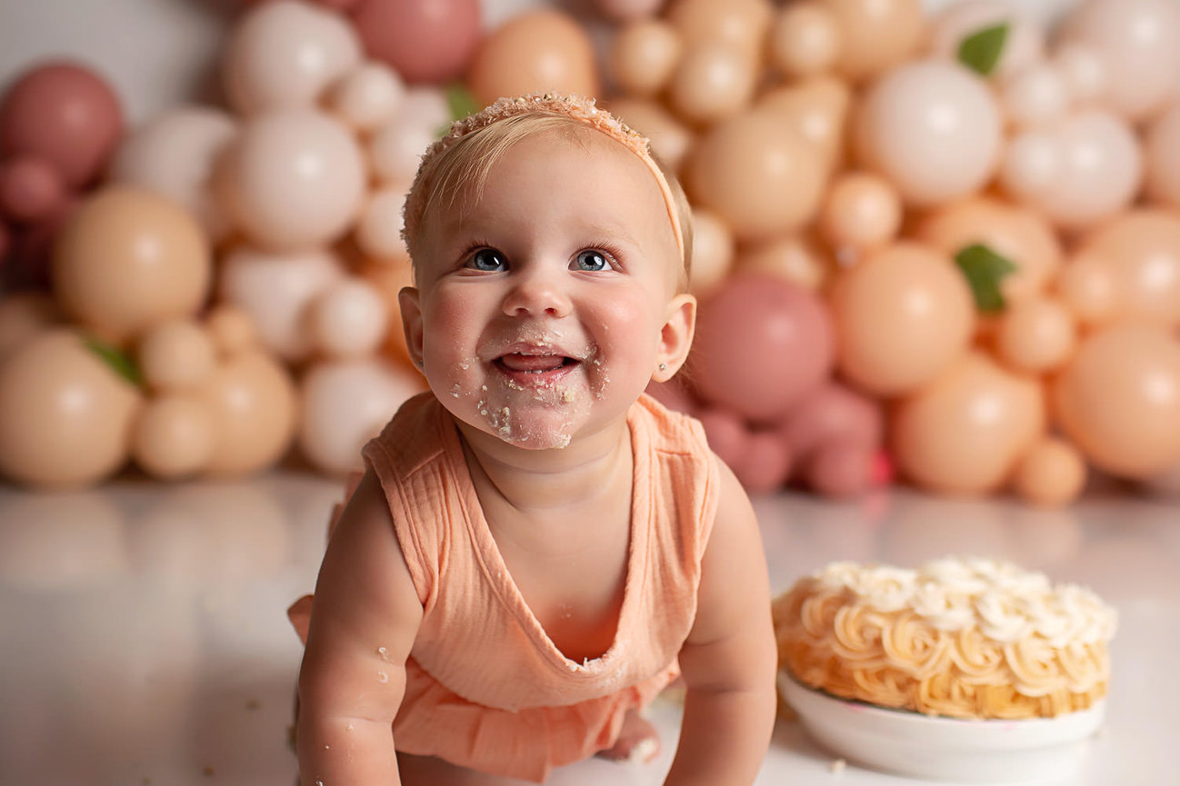 baby girl crawling during first birthday cake smash photoshoot with baby photographer Dreamworks Photography in Kansas City photography studio