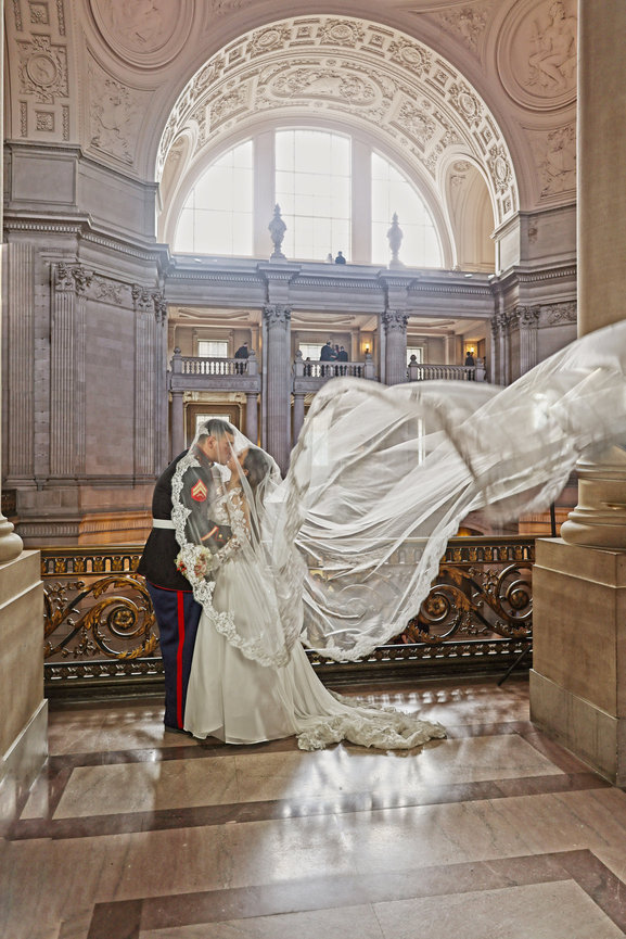 Luxury San Francisco City Hall wedding photography of bride and groom with dramatic veil movement, elegant architecture, and editorial-style portrait