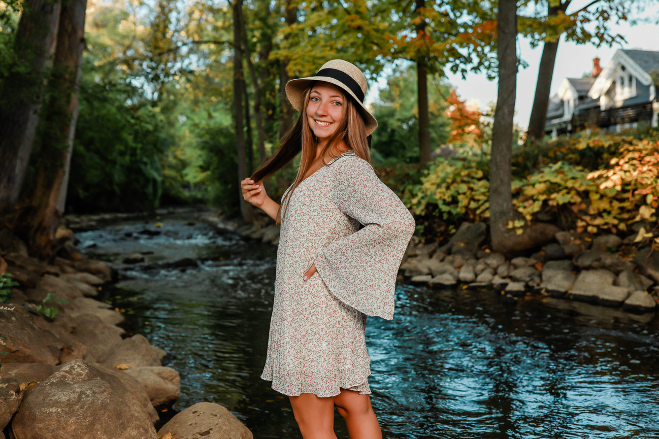 Senior girl wearing hat in outdoor photo session by water