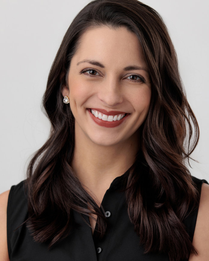 A beautiful brunette woman wearing black smiling for a professional in studio headshot in Fishers, IN.